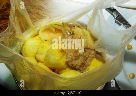 Biologisch abbaubarer Müll. Übrig gebliebene Zitronenschale, Samen und Zitronenpulpe in einem Plastikbeutel. Stockfoto