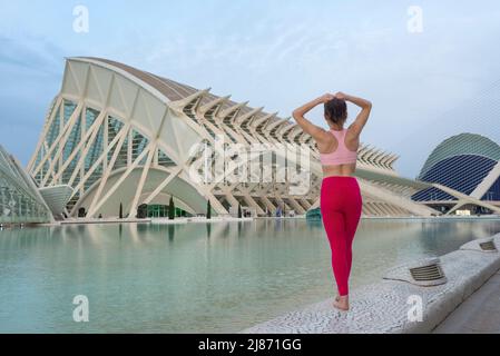 Eine sportliche Frau, die ihr Haar in der Stadt der Künste und Wissenschaften, Valencia, spanien, für die Ausübung bereit bindet. Stockfoto