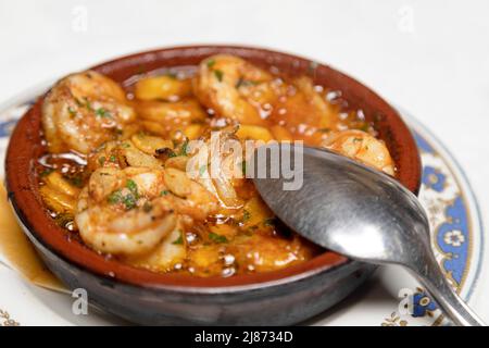 Garnelen, die in Olivenöl mit Knoblauch (Gambas al ajillo) gekocht werden, werden als Vorspeise in einem Restaurant auf Teneriffa, Spanien, serviert. Das Gericht ist ein beliebtes und traditi Stockfoto