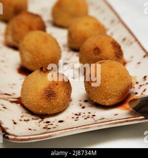 Kroketten (Croquetas) gefüllt mit Käse als Vorspeise auf Teneriffa serviert. Die frittierten Bällchen sind auch eine beliebte Tapas. Stockfoto