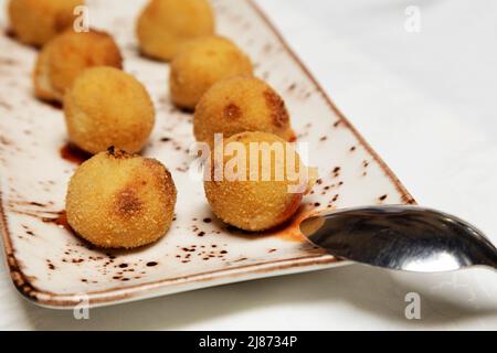 Kroketten (Croquetas) gefüllt mit Käse als Vorspeise auf Teneriffa serviert. Die frittierten Bällchen sind auch eine beliebte Tapas. Stockfoto