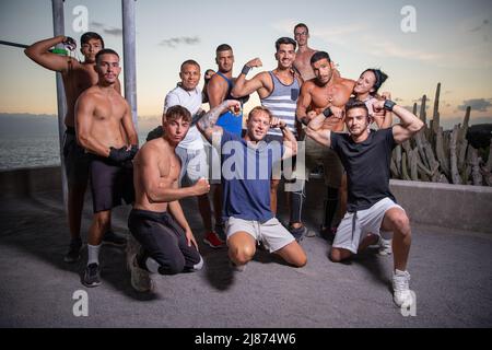 Eine Gruppe von glücklichen Athleten zusammen nach dem Ende eines Workouts in der Outdoor-Turnhalle, sportliche Menschen zusammen Stockfoto
