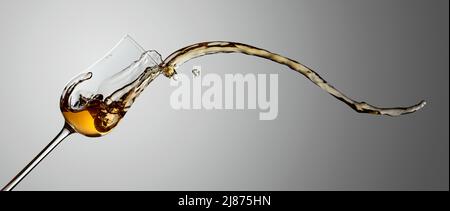 Das Getränk wird aus dem Glas verschüttet. Konzept des Themas Premium-Alkohol. Speicherplatz kopieren. Stockfoto