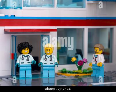 Tambow, Russische Föderation - 11. Februar 2022 drei Minifiguren des Lego-Arztes, die in der Nähe des Eingangs eines Krankenhauses stehen Stockfoto