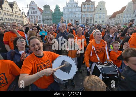 Rostock, Deutschland. 13.. Mai 2022. Fans der Rostock Seawolves stehen auf dem Neuen Markt und feiern die Beförderung der Herren-Basketballmannschaft der Rostock Seawolves zur Basketball-Bundesliga 1.. In der letzten Sekunde hatte das Team mit 77:76 in Jena gewonnen und steigt damit erstmals in der Bundesliga. Quelle: Danny Gohlke/dpa/Alamy Live News Stockfoto