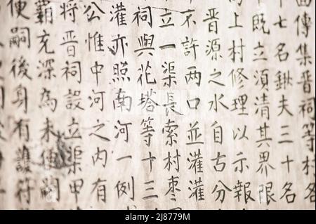 Eine Tabelle mit chinesischen Schriftzeichen in einem Stein gemeißelt. Hintergrund. Stockfoto