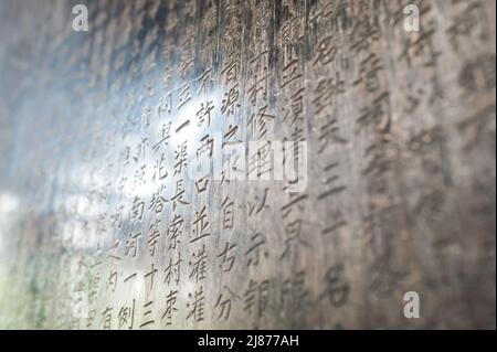 Eine Tabelle mit chinesischen Schriftzeichen in einem Stein gemeißelt. Hintergrund. Stockfoto