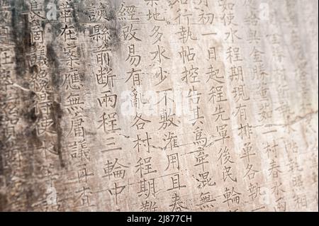 Eine Tabelle mit chinesischen Schriftzeichen in einem Stein gemeißelt. Hintergrund. Stockfoto