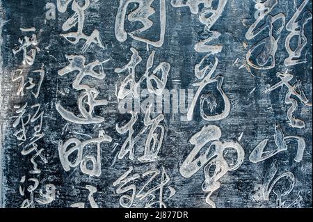 Eine Tabelle mit alten chinesischen Schriftzeichen in einem Stein gemeißelt. Hintergrund. Stockfoto