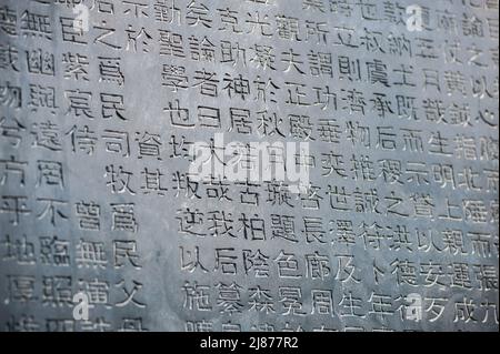 Eine Tabelle mit chinesischen Schriftzeichen in einem Stein gemeißelt. Hintergrund. Stockfoto