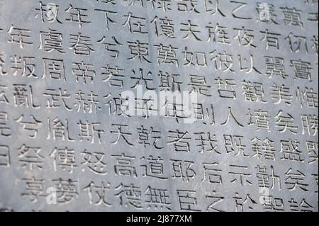 Eine Tabelle mit chinesischen Schriftzeichen in einem Stein gemeißelt. Hintergrund. Stockfoto