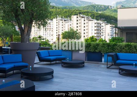 Igalo, Montenegro, August 2021. Blaue Sofas und Tische auf der Restaurantterrasse während der Pandemie. Erholungsgebiet. Stockfoto