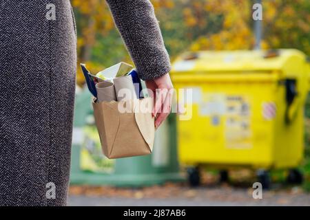 Bewusst Frau, die Papier von anderen Abfällen trennt und es in grünen Behälter legt, um natürliche Ressourcen in Prag Chezh zu sparen Stockfoto