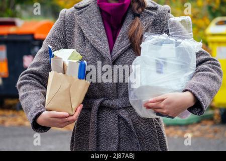 Bewusst Frau, die Papier von anderen Abfällen trennt und es in grünen Behälter legt, um natürliche Ressourcen in Prag Chezh zu sparen Stockfoto