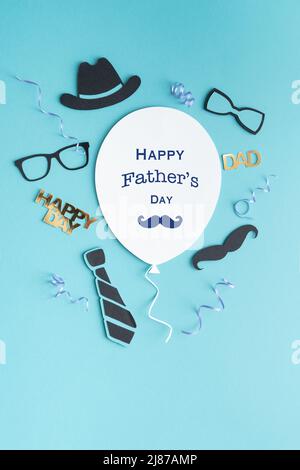 Vatertag Grußballon-Karte mit Symbolen Dekoration auf Papier auf blauem Hintergrund. Speicherplatz kopieren. Vertikales Foto. Stockfoto