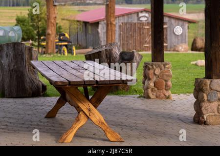 Ein Tisch, der in einem offenen Holzpavillon auf dem Gelände neben dem Anwesen steht. Stockfoto