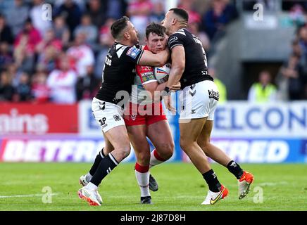 Ben Davies von St. Helens (Mitte) wird von Josh Reynolds von Hull FC (links) und Carlos Tuimavave während des Betfred Super League-Spiels im total Wicked Stadium, St. Helens, angegangen. Bilddatum: Freitag, 13. Mai 2022. Stockfoto