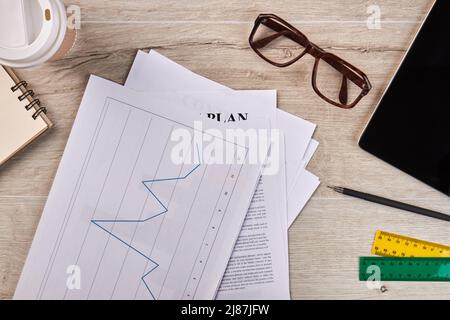 Arbeitspapiere mit statistischer Grafik und Brille. Draufsicht flach liegend. Stockfoto