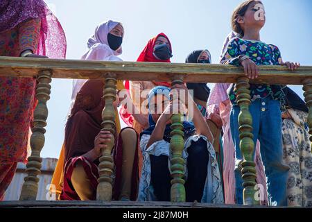 Srinagar, Indien. 12.. Mai 2022. Kinder aus Kashmiri beobachten, wie Menschen den Sarg mit dem Leichnam des getöteten Polizeidiensthabers Reyaz Ahmad Thokar in seinem Heimatdorf Gudoora Pulwama tragen. Es wird vermutet, dass Thokar von Militanten außerhalb seines Wohnsitzes in Süd-Kaschmir getötet wurde. (Foto von Faisal Bashir/SOPA Images/Sipa USA) Quelle: SIPA USA/Alamy Live News Stockfoto