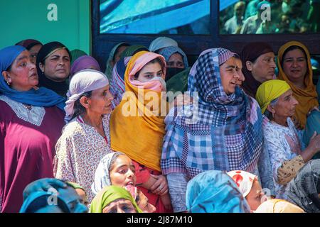 Srinagar, Indien. 12.. Mai 2022. Kaschmirische Frauen trauern, während Menschen den Sarg mit dem Leichnam des getöteten Polizeidiensthabers Reyaz Ahmad Thokar in seinem Heimatdorf Gudoora Pulwama tragen. Es wird vermutet, dass Thokar von Militanten außerhalb seines Wohnsitzes in Süd-Kaschmir getötet wurde. (Foto von Faisal Bashir/SOPA Images/Sipa USA) Quelle: SIPA USA/Alamy Live News Stockfoto