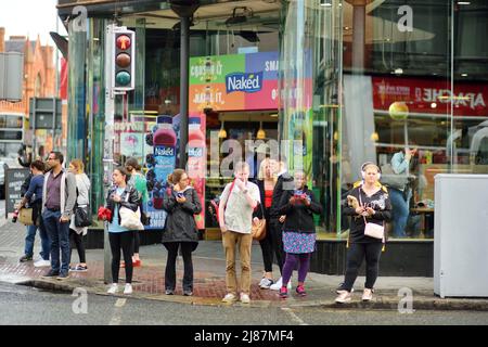 DUBLIN, IRLAND - MAI 2018: Geschäftiges Alltagsleben von Touristen und Stadtbewohnern in Dublin, Irland. Menschen, die auf den Straßen der Iri ihr Geschäft verführen Stockfoto
