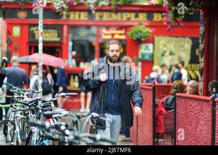 DUBLIN, IRLAND - MAI 2018: Geschäftiges Alltagsleben von Touristen und Stadtbewohnern in Dublin, Irland. Menschen, die auf den Straßen der Iri ihr Geschäft verführen Stockfoto