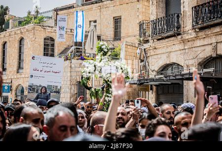 Jerusalem, Israel. 13.. Mai 2022. Menschenmengen von Trauernden kommen während der Trauerprozession von Abu Aklei zu Besuch. Abu Aklei wurde am Mittwochmorgen im besetzten Westjordanland getötet, als sie einen israelischen Angriff auf die Stadt Jenin verdeckte. Zeugen sagten, dass sie von einem israelischen Soldaten getötet wurde. Die israelische Armee sagte am Freitag, dass Frau Abu Aklei, obwohl es möglich war, versehentlich durch einen israelischen Brand getötet wurde; ihre ersten Ermittlungen lassen vermuten, dass sie auch von einem palästinensischen Schützen getroffen worden sein könnte. Kredit: SOPA Images Limited/Alamy Live Nachrichten Stockfoto