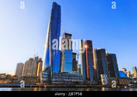 Steigen Sie von der Fähre über die Hafengewässer gegen den blauen Himmel auf die hohen modernen Stadttürme von Barangaroo im zentralen Geschäftsviertel von Sydney. Stockfoto