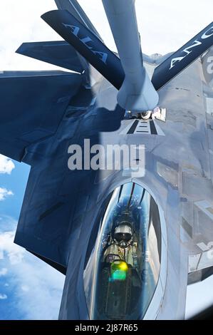 Ein Pilot der US Air Force F-22 dockt mit dem KC-135 Stratotanker an, der dem 117. Air Betanking Wing, Alabama Air National Guard, während einer Tankaufübung vor der Küste von Jacksonville, Florida, für Sentry Savannah 22-1 am 12. Mai 2022 zugewiesen wurde. Übungen wie Sentry Savannah im Air Dominance Center trainieren und testen nicht nur die Gegenluftfähigkeiten der nächsten Generation von Kampfpiloten, sondern sie bieten auch kritische Erfahrung und Training für 10 verschiedene Wartungseinheiten von Airmen in der schnellen Beschäftigung und Bergung von Flugzeugen. Stockfoto