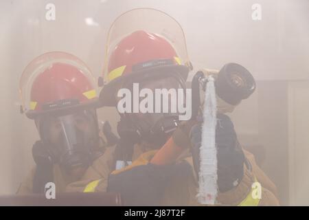 220506-N-VQ947-1060 SAN DIEGO (6. Mai 2022) – Personnel Specialist 2. Klasse Haley Wilkinson, links, und Yeoman 1. Klasse Michael Cruz, rechts, verwickeln einen simulierten Klasse-Alpha-Brand während einer allgemeinen Übung an Bord des Amphibientransportsdocks USS Portland (LPD 27), 6. Mai 2022. Portland ist ein Amphibientransportsdock der San Antonio-Klasse, das in San Diego heimisch ist. (USA Navy Foto von Mass Communication Specialist 2. Class Devin Kates) Stockfoto