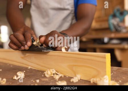 Mittelteil der afroamerikanischen reifen Zimmermannshausdiele in der Werkstatt Stockfoto