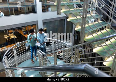 Aus der Perspektive afroamerikanischer Kollegen, die über die Akte auf der Treppe am Arbeitsplatz diskutieren Stockfoto