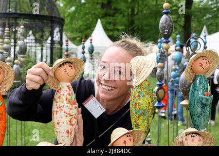 Dobbelin, Deutschland. 13.. Mai 2022. 13. Mai 2022, Sachsen-Anhalt, Döbbelin: Aussteller Janine Bockus aus Bamberg, richtet ihre Keramikgärtner aus. Zum achten Mal findet auf 8 Hektar 'LebensArt', der Messe für Garten, Wohnen und Lifestyle auf Schloss Bismarck Döbbelin, statt. Weit über 120 Aussteller präsentieren sich bis Sonntag im Schlossgarten, alles rund um das Thema Garten, Dekorationen und Blumen. Foto: Peter Gercke/dpa Quelle: dpa picture Alliance/Alamy Live News Stockfoto