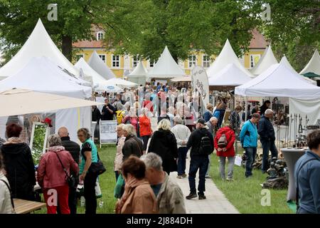 Dobbelin, Deutschland. 13.. Mai 2022. 13. Mai 2022, Sachsen-Anhalt, Döbbelin: Besucher spazieren durch den Schlosspark auf der Messe 'LebensArt', der Ausstellung für Garten, Wohnen und Lifestyle auf Schloss Bismarck Döbbelin . Weit über 120 Aussteller präsentieren sich bis Sonntag im Schlossgarten, alles rund um das Thema Garten, Dekorationen und Blumen. Foto: Peter Gercke/dpa Quelle: dpa picture Alliance/Alamy Live News Stockfoto