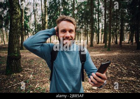 Junge erwachsene Mann am Telefon zu sprechen stehend über weiße Mauer mit Hand betonte am Kopf, mit Scham und Überraschung Gesicht schockiert, wütend und frustr Stockfoto