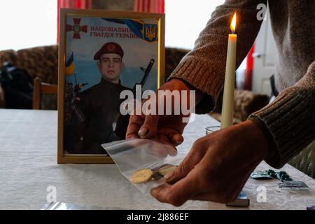 Balabyne, Ukraine. 13.. Mai 2022. Die Mutter des verstorbenen Sergej Titow, Sergeant der Nationalgarde, der durch russischen Beschuss getötet wurde, zeigt seine Medaillen. Russland marschierte am 24. Februar 2022 in die Ukraine ein und löste damit den größten militärischen Angriff in Europa seit dem Zweiten Weltkrieg aus Kredit: SOPA Images Limited/Alamy Live Nachrichten Stockfoto