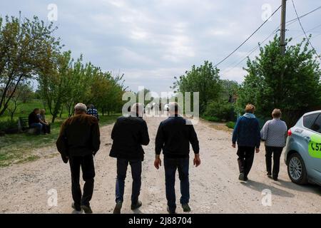 Balabyne, Ukraine. 13.. Mai 2022. Die Menschen verlassen das Begräbnis im Dorf Balabyne. Russland marschierte am 24. Februar 2022 in die Ukraine ein und löste damit den größten militärischen Angriff in Europa seit dem Zweiten Weltkrieg aus (Foto von Rick Mave/SOPA Images/Sipa USA) Quelle: SIPA USA/Alamy Live News Stockfoto