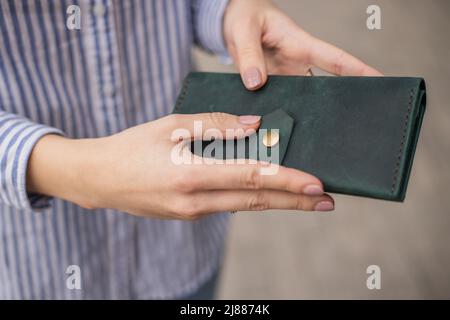 Sky blue Handtasche Geldbörse und schöne Frau Hand mit Maniküre. Verschwommener Hintergrund Stockfoto