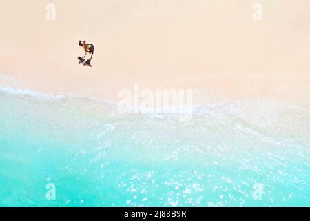 Ein paar Spaziergänge am Strand von Mauritius im Indischen Ozean. Draufsicht auf den Strand mit türkisfarbenem Wasser auf der tropischen Insel Mauritius.Luftaufnahme Stockfoto