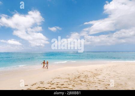 Ein paar Spaziergänge am Strand von Mauritius im Indischen Ozean. Draufsicht auf den Strand mit türkisfarbenem Wasser auf der tropischen Insel Mauritius.Luftaufnahme Stockfoto