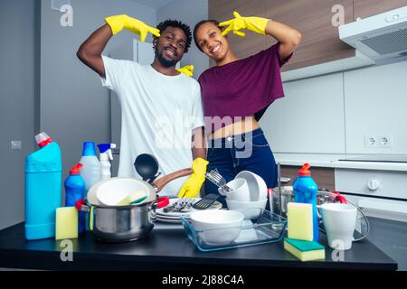 Unglückliches, müde afroamerikanisches Paar, das neben dem Tisch voller schmutziger Teller und Tassen stand Stockfoto