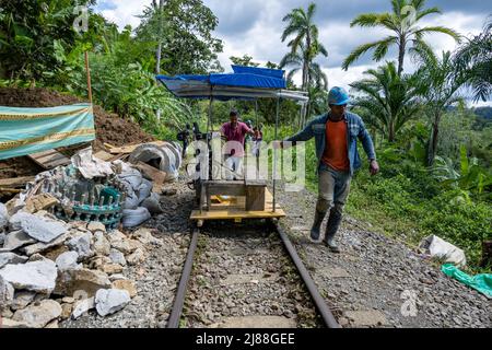 Brujita, ein Holzkarren, der von einem umgebauten Motorrad auf der Schiene angetrieben wird, ist eine einzigartige Form des Transports in der ländlichen Gegend. San Cipriano, Kolumbien. Stockfoto