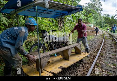 Brujita, ein Holzkarren, der von einem umgebauten Motorrad auf der Schiene angetrieben wird, ist eine einzigartige Form des Transports in der ländlichen Gegend. San Cipriano, Kolumbien. Stockfoto