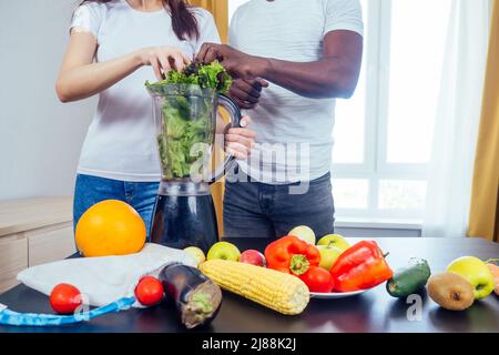 afroamerikanischer Mann mit asiatischer Frau, die zu Hause Smoothie macht Stockfoto