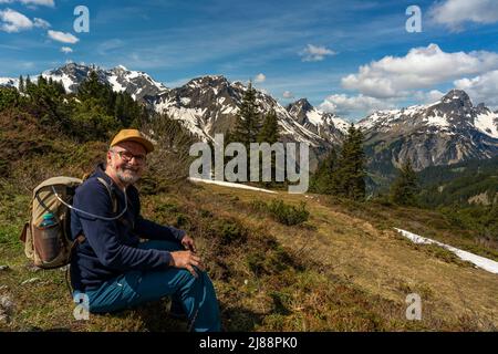 Wanderer mit Sauerstoffstützung im Bregenzerwald auf dem Weg zum Körbersee. Nach Covid-19 inkl. 1 Monat Koma ist es die erste Bergtour. Stockfoto