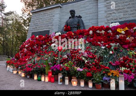 Tallinn, Estland - 12. Mai 2022: Bronze Soldat (est: Pronkssõdur) Denkmal. Veteranen der Roten Armee feiern den Victory Day mit roten Nelkenblumen Stockfoto