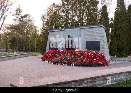 Tallinn, Estland - 12. Mai 2022: Bronze Soldat (est: Pronkssõdur) Denkmal. Veteranen der Roten Armee feiern den Victory Day mit roten Nelkenblumen Stockfoto