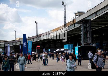 Berlin, Deutschland. 14.. Mai 2022. Formel E: Berlin E-Prix im Tempelhofer Feld, Qualifying: Vor dem Hangar am alten Standort des Flughafens Berlin-Tempelhof laufen die Leute. Quelle: Fabian Sommer/dpa/Alamy Live News Stockfoto