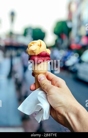 Türkisches Eis Dondurma in der Hand auf dem Hintergrund der Stadt Stockfoto