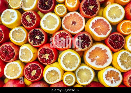 Hintergrund von geschnittener Orange, Granatapfel, Zitrone. Seitenansicht Stockfoto